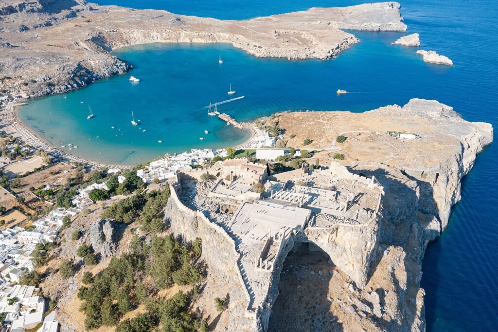 Aerial view of Lindos Acropolis, whitewashed village and beach