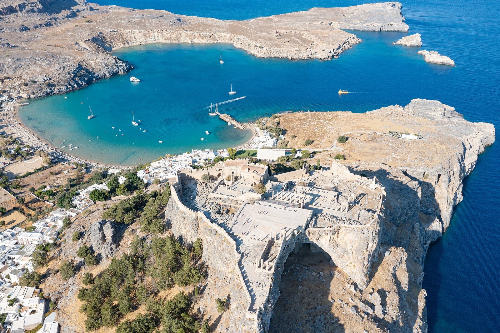 Aerial view of Lindos Acropolis, whitewashed village and beach