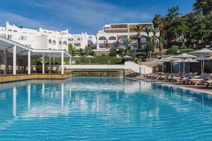 Pool and whitewashed hillside buildings of Lindos Village Resort & Spa above Vlycha Bay, Rhodes